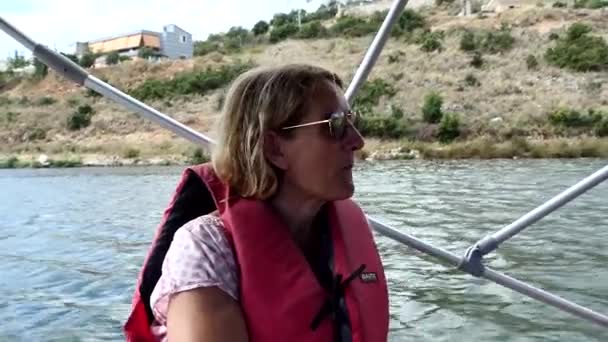 Arnavutluk 'un Ksamil kentinde can yeleği giyen bir kadın Butrint Gölü' nde midye hasat teknesine biniyor..   - Video, Çekim