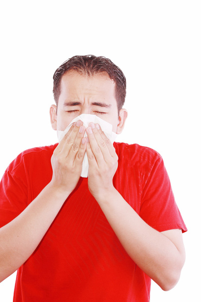 Young man with a cold blowing nose on tissue - Photo, Image