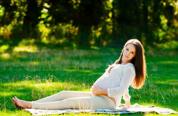 Jeune femme enceinte se détendre dans le parc à l'extérieur, grossesse en bonne santé
 - Photo, image