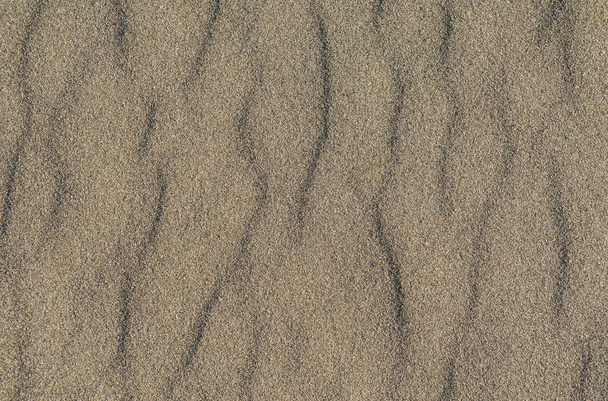 Closeup de padrão de areia vulcânica de uma praia no verão
 - Foto, Imagem