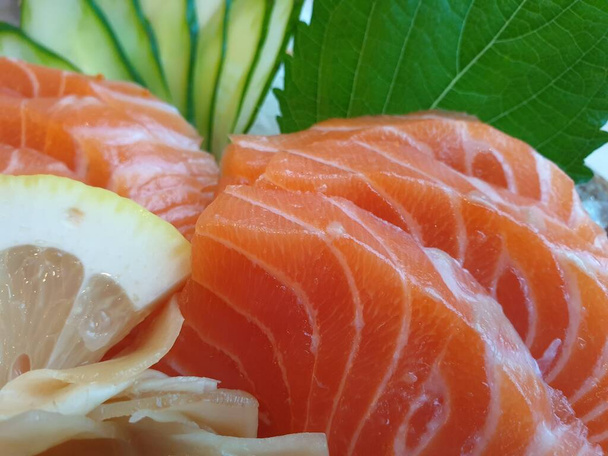 Japanilainen ruoka sashimi-lohi ja asettaa erilaisia sushia merileväsalaatilla ja garilla (inkivääri) on terveellinen ruoka japanilaisen ravintolan tarjoilupöydän oikeassa yläkulmassa. - Valokuva, kuva