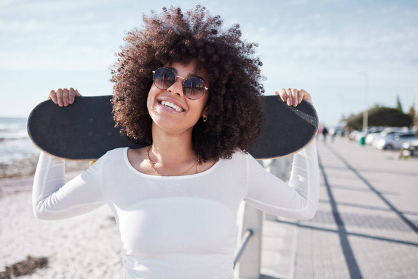 молодая женщина тусуется на набережной со своим скейтбордом. - Фото, изображение