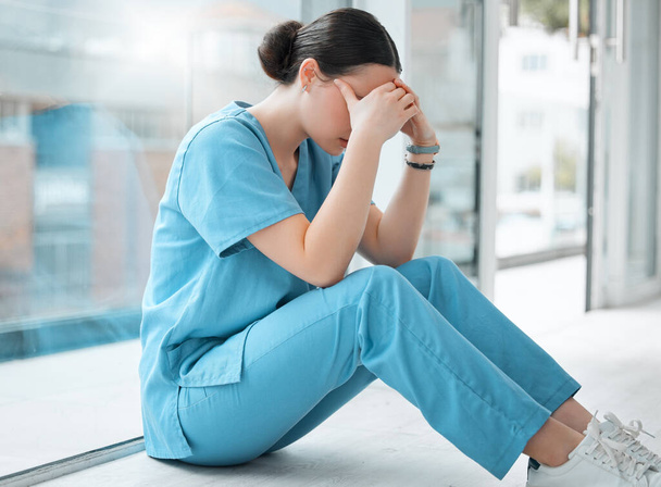 egy fiatal női orvos, aki stresszesen néz ki munka közben a kórházban,. - Fotó, kép