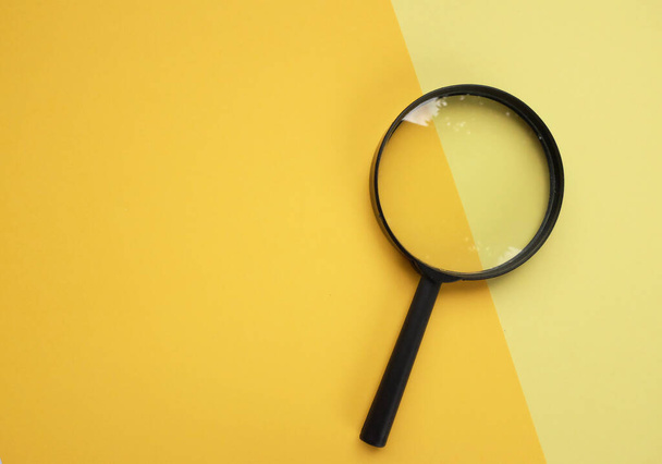 black round magnifying glass onyellow pastel background. used for searching or expanding books. - Fotoğraf, Görsel