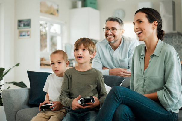 una familia jugando videojuegos juntos en casa. - Foto, Imagen