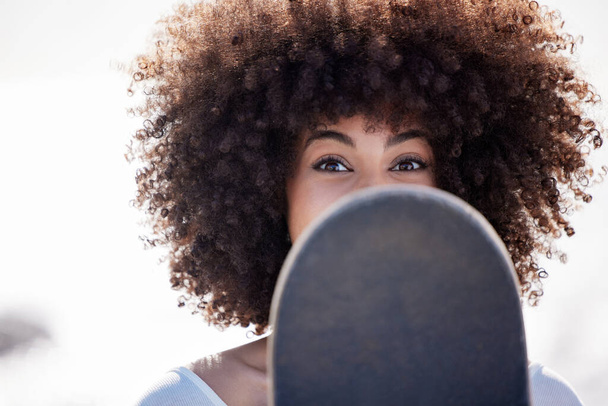 Portrait of a young woman hanging out at the promenade with her skateboard. - 写真・画像