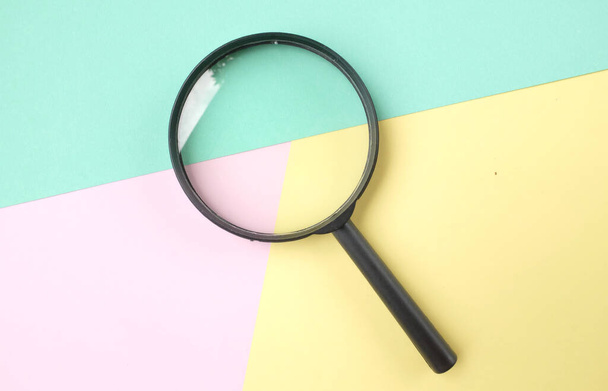 magnifying glass search symbol  on a multi colored paper background - Valokuva, kuva