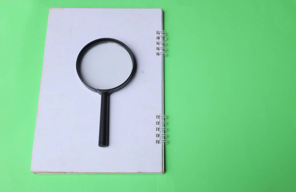 magnifying glass search symbol on notepads isolate a green background - Valokuva, kuva