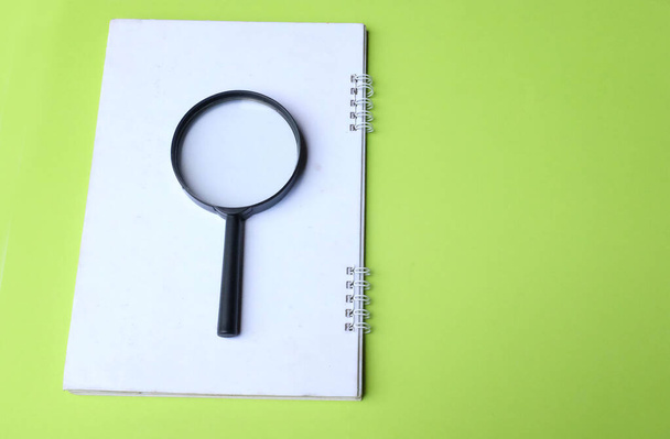 magnifying glass search symbol on notepads isolate a green background - Foto, Imagem