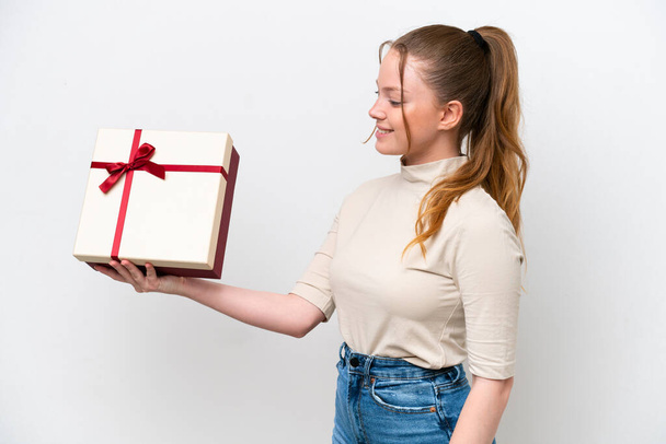 Young caucasian woman holding a gift isolated on white background with happy expression - Fotoğraf, Görsel