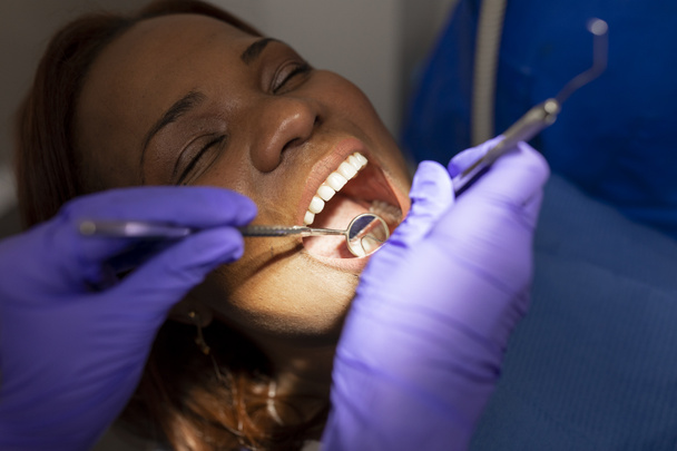 Hammaslääkäri naisten kädet käyttäen hammaslääkärin työkaluja hoitoon potilaiden suullinen kysymyksiä, kun istuu hammashoitola - Valokuva, kuva
