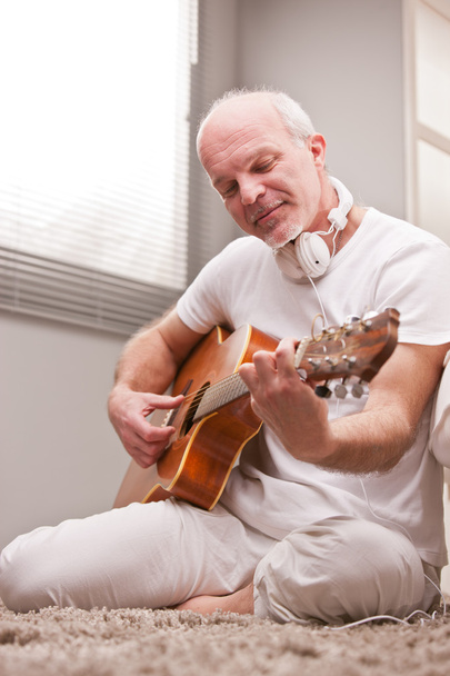 mature man playing guitar at home - Fotoğraf, Görsel