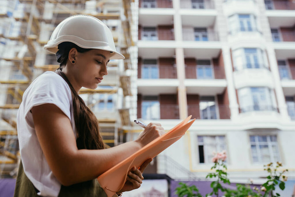 Žena stavební inženýr nosit bezpečnost bílý pevný klobouk na staveništi dělníka. Ženská konstrukce Koncept ženského konstruktéra - Fotografie, Obrázek