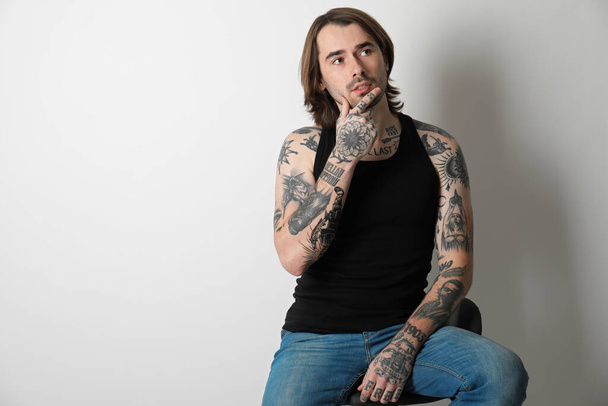 Young man with tattoos on body against white background - Photo, image