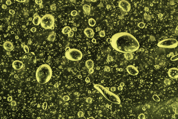 Burbujas de aire verdes en un líquido oscuro. Fondos y texturas - Foto, Imagen