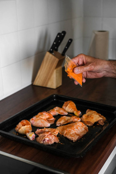 an adult man marinates meat for cooking dinner in the oven - Valokuva, kuva