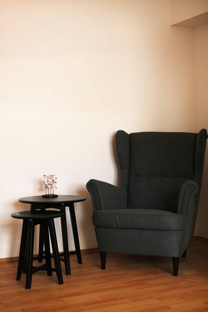dark gray armchair with a coffee table in a bright Scandinavian-style living room - 写真・画像