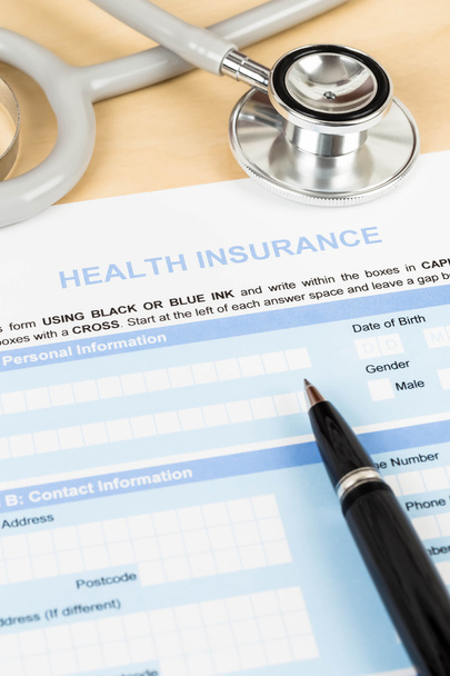 Modulo di domanda di assicurazione sanitaria con penna e stetoscopio conce
 - Foto, immagini