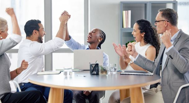 a group of businesspeople cheering while working in an office. - Foto, imagen