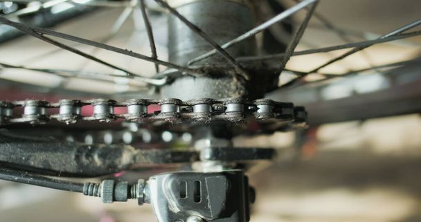 the bicycle chain rotates the rear wheel of the bicycle, the sprocket is spinning, close-up. Top view of an inverted bicycle wheel with a planetary hub. The rotation of a spoked wheel. High quality 4k - Photo, Image