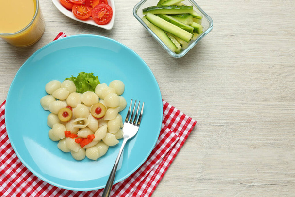 Tasty pasta served with vegetables on wooden table, flat lay. Creative idea for kid lunch - Photo, image
