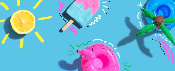 Summer concept with a flamingo float, lemon sunlight and a popsicle - flat lay - Foto, Imagen