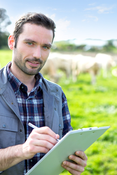 Young attractive farmer working in a field - Foto, Imagen