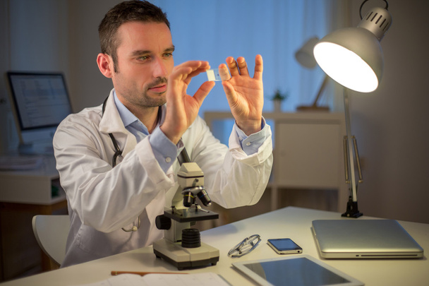 Young attractive scientist working late at office - Photo, Image