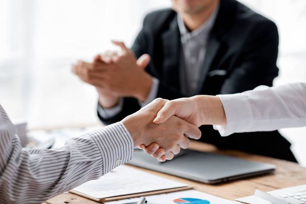 ビジネス投資家グループが手を取り合い、 2人のビジネスマンがビジネスに合意し、交渉が成功した後で握手をしています。握手は西洋の挨拶やお祝いです. - 写真・画像