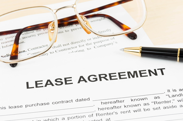Documento de contrato de locação com óculos e caneta
 - Foto, Imagem