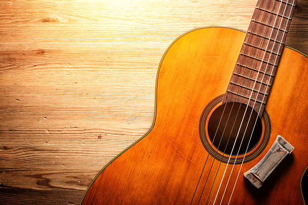 Крупный план классической гитары с гармоникой на деревянном фоне - Фото, изображение