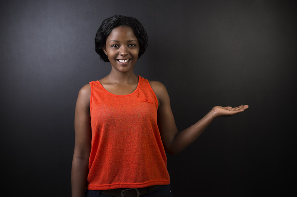 Sudafrica o afro-americano insegnante donna su sfondo gesso lavagna nera
 - Foto, immagini