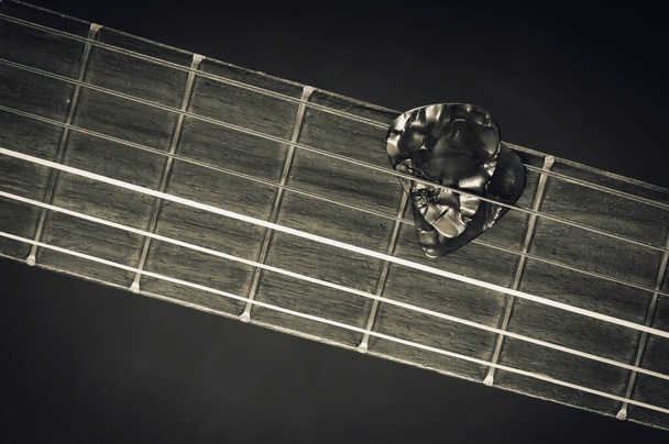 Primer plano de selección de guitarra en una vieja guitarra clásica. Una selección de guitarra es un plectrum utilizado para guitarras. - Foto, imagen