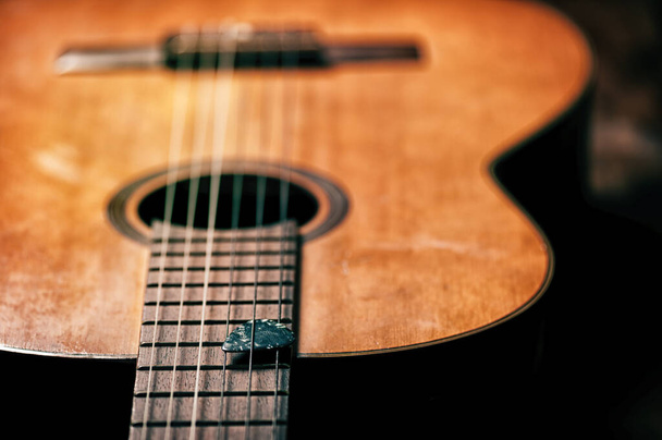 Closeup guitar pick on an old classical guitar. A guitar pick is a plectrum used for guitars. - Foto, imagen
