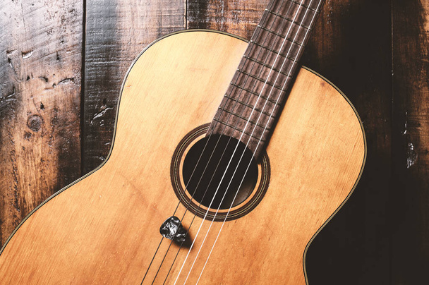 classical guitar with guitar pick on wooden background - Foto, Imagem