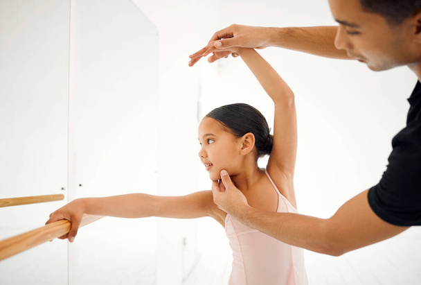 μια δασκάλα μπαλέτου που βοηθάει μια μαθήτρια με τη θέση της σε μια σχολή χορού. - Φωτογραφία, εικόνα