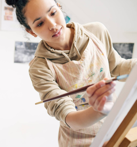 Χαμηλή γωνία ενός ελκυστικού νεαρή γυναίκα ζωγραφική σε ένα καμβά στο στούντιό της. - Φωτογραφία, εικόνα