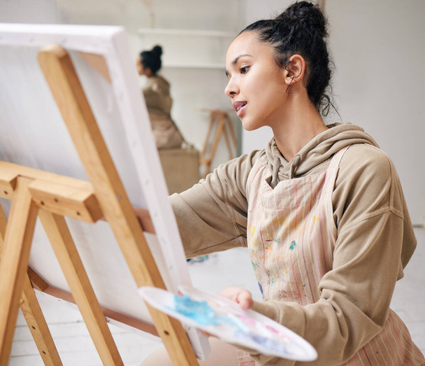 Hoge hoek foto van een aantrekkelijke jonge vrouw schilderij op een doek in haar atelier. - Foto, afbeelding