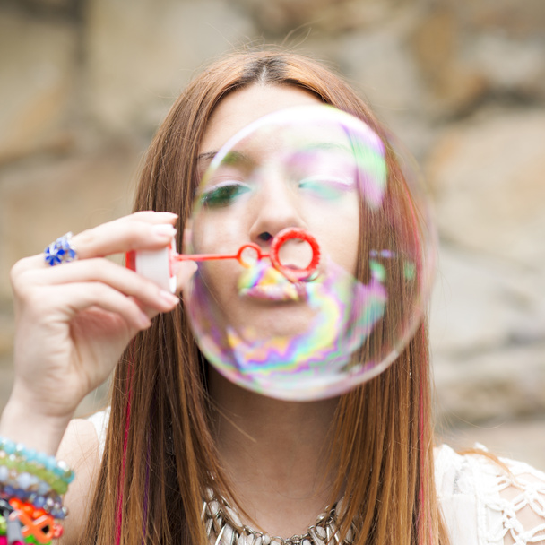 Primer plano retrato de hermosa mujer inflando coloridas burbujas de jabón
. - Foto, imagen