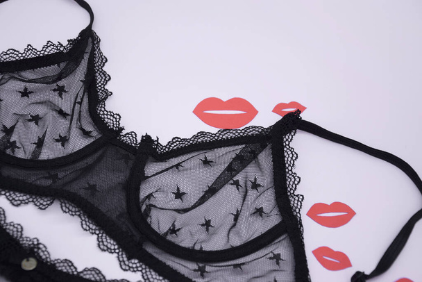 Lace sexy black women's underwear, with red kisses on a light background. Black lace underwear. Fashion concept. Women's bra, panties, erotic clothes. underwear advertisement - Foto, imagen