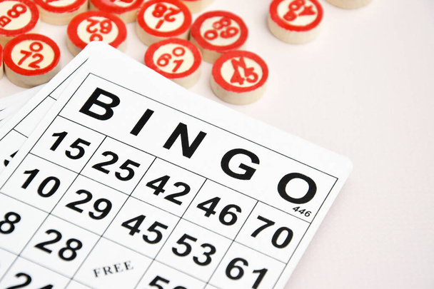 Viele Holzchips mit Zahlen und Karten für ein Brettspiel wie Bingo oder Lotto auf hellem Hintergrund. Russisches Lotto hat ähnliche Regeln wie das klassische weltweite Bingospiel. - Foto, Bild