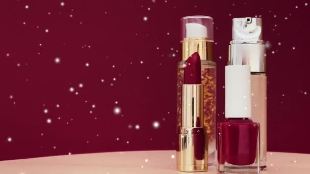 Punainen huulipuna, nestemäinen perustus ja kynsilakka pullot luksusmeikkituotteet ja lumi vaikutus joulun, kosmetiikan ja kauneuden brändi käsite - Materiaali, video
