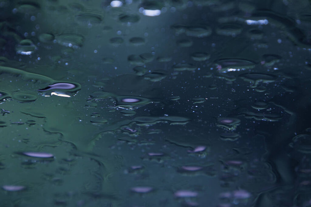 Abstrakter Hintergrund mit Wassertropfen auf Glas mit selektivem Fokus. Hintergrund mit nassem Glas, mit Wassertropfen Textur. Weicher Fokus. - Foto, Bild