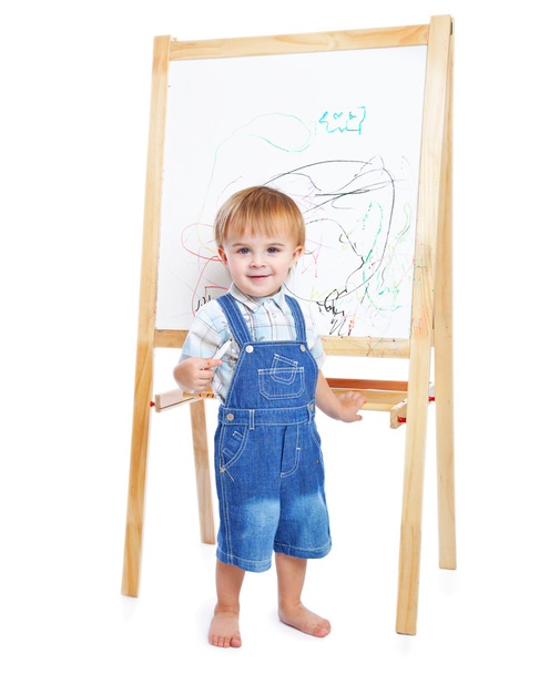 Ein Junge zeichnet an einer Tafel. isoliert auf weißem Hintergrund - Foto, Bild