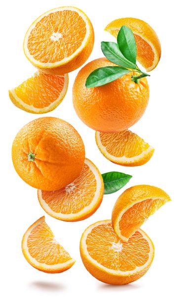 Reife Orangen mit Hälften und Scheiben mit Orangenblättern fallen zufällig herab oder schweben auf weißem Hintergrund. Saftiger Hintergrund für Ihr Projekt. Steilpfad. - Foto, Bild