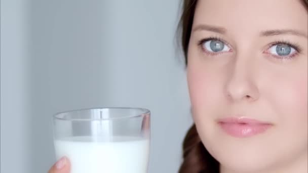 Ευτυχισμένη νεαρή γυναίκα με ένα ποτήρι γάλα ή κοκτέιλ πρωτεϊνών, υγιεινό ποτό, δίαιτα και ευεξία - Πλάνα, βίντεο
