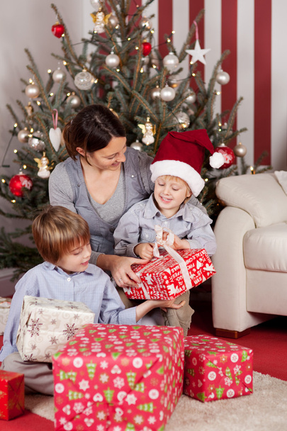 Young family opening Christmas gifts - Фото, зображення