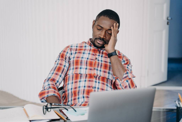 Sleepy tired online teacher gets headache. Afro man has online conference or working on laptop. Businessman talking to client. Employee busy with project. Teacher speaking to student. Online courses. - Fotó, kép