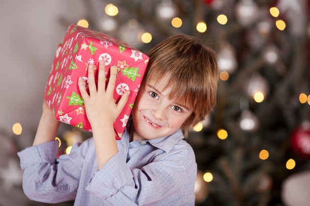 Male Kid Carrying Christmas Present - 写真・画像