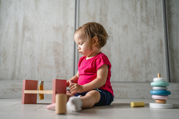 one child small caucasian girl little toddler playing with educational toys at home childhood and growing up early development concept copy space front view - 写真・画像